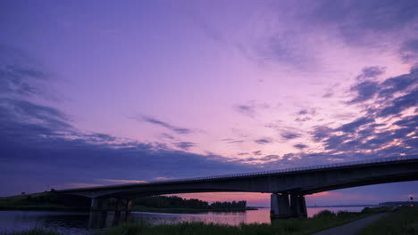 El-Cielo-Se-Vuelve-Morado-Mientras-El-Sol-Se-Pone-Lentamente-Detrás-De-Este-Puente-De-Carretera