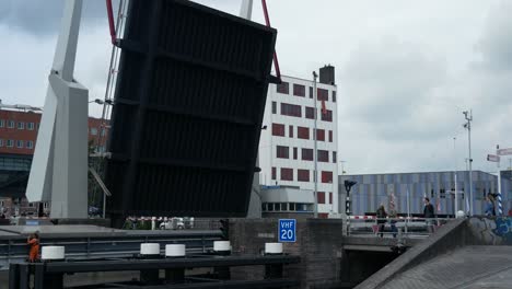 Barco-Largo-Que-Pasa-Bajo-Un-Puente-Levadizo-Móvil-Durante-Un-Día-Nublado-En-Alkmaar,-Países-Bajos