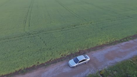 Das-Auto-Fährt-über-Eine-Schotterstraße-Auf-Eine-Windkraftanlage-Auf-Landwirtschaftlichen-Feldern-Zu