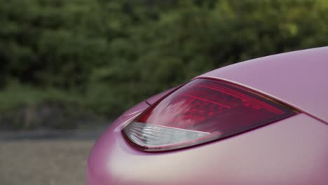 El-Cielo-Se-Refleja-En-La-Luz-Trasera-Roja-Del-Coche-Deportivo-De-Dos-Plazas-Porsche-Boxster-Revestido-De-Rosa