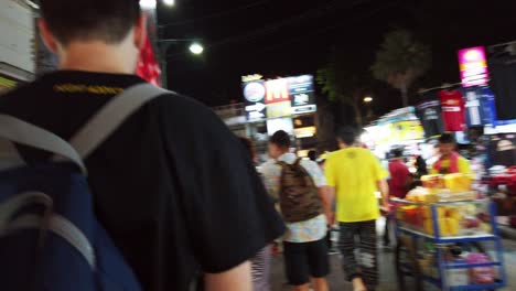 Handheld-scenes-of-the-tourists-are-walking-around-Khao-San-Road-at-night-time-famous-which-each-year-tourists-from-many-countries-came-to-visit-in-Bangkok,-Thailand