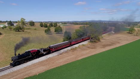 Aerial-View-of-a-Antique-Steam-Engine-Puffing-along-Pulling-Antique-Passenger-Cars-Through-Amish-Farm-Lands-on-a-Sunny-Autumn-Day-as-Seen-by-a-Drone