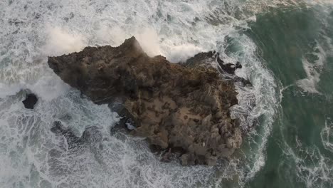 Ocean-waves-crash-against-rugged-rock-outcropping-in-South-Africa,-aerial