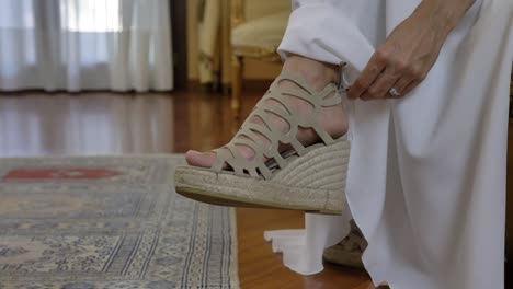 Female-Bride-Tying-Lace-at-the-Back-of-Her-Shoe-While-Sitting-Down-Inside