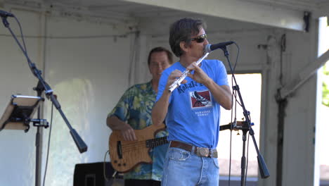 Carefree-flutist-performing-at-Californian-county-fair,-medium-shot