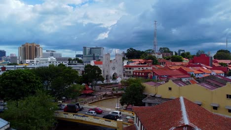 Aerial-forward-shot-of-historical-malaysian-buildings-during-dramatic-clouds-at-sky