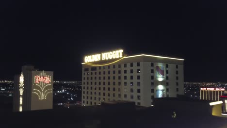 4K-Luftaufnahme:-Dynamische-Luftaufnahme-über-Dem-Golden-Nugget-Hotel-Und-Casino-In-Las-Vegas-Mit-Den-Lichtern-Der-Stadt-Im-Hintergrund-In-Der-Abenddämmerung