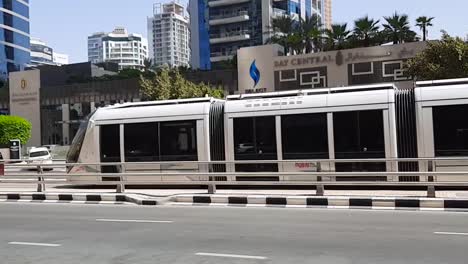 Metro-Tren-Subterráneo-Moviéndose-A-Través-De-Las-Calles-De-La-Ciudad-De-Izquierda-A-Derecha-En-Medio-Del-Caluroso-Día-En-La-Residencia-De-La-Playa-De-Jumeirah-Solo-Vehículos-De-La-Calle-Lateral-Lento-Pan-B-Roll-Clip