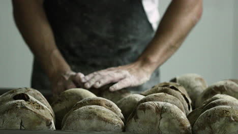 Panadero-Organizando-Los-Panes-De-Masa-Fermentada-En-Una-Rejilla-Para-Hornear-En-Una-Panadería