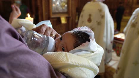 Recién-Nacido-Bebiendo-Leche-Durante-El-Bautizo-En-La-Iglesia-En-Rumania