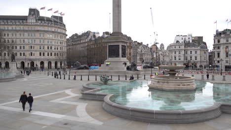 Ein-Paar-Menschen-Gehen-über-Einen-Leeren-Trafalgar-Square,-Einen-Tag-Nachdem-Premierminister-Boris-Johnson-Die-Britische-Bevölkerung-Gewarnt-Hat,-Aufgrund-Des-Coronavirus-Ausbruchs-Alle-Nicht-Unbedingt-Notwendigen-Sozialen-Kontakte-Zu-Vermeiden