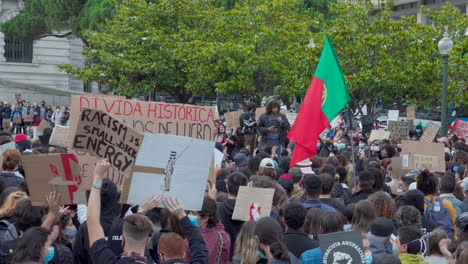 Porto---Portugal---june-6th-2020:-BLM-Black-Lives-Matter-Protests-Demonstration-with-protesters-holding-black-lives-matter-signs-in-the-air-and-cheering-speaker-with-portuguese-flag