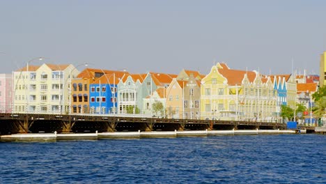 Königin-Emma-Brücke-Mit-Farbenfrohen-Und-Historischen-Gebäuden-Im-Hintergrund-In-Punda,-Willemstad,-Curaçao