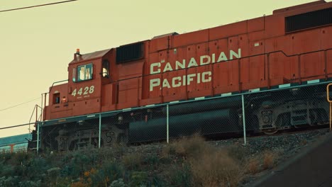 Estacionamiento-Del-Tren-De-Carga-De-La-Locomotora-Del-Motor-Diesel-Del-Ferrocarril-Del-Pacífico-Canadiense-En-El-Puente-Del-Patio-Del-Ferrocarril-De-La-Ciudad-Industrial-Con-Una-Fuerte-Contaminación-Del-Aire-Durante-La-Puesta-De-Sol-Anochecer-Cinemático-Toronto-Ontario-Prores-4k