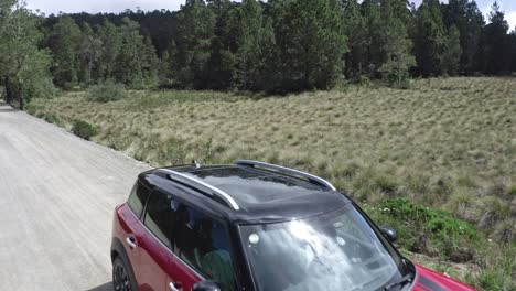 Volando-Sobre-Un-Coche-Mini-Countryman-Rojo-Estacionado-A-Lo-Largo-De-Una-Carretera-Rural-En-Una-Zona-Rural