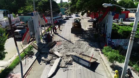 Vista-Aérea-De-Drones-De-Una-Excavadora-Y-Trabajadores-Limpiando-Las-Secuelas-De-La-Tormenta,-En-Las-Calles-De-La-Ciudad-De-Cancún