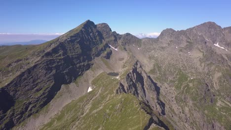 Drohne-Hoch-über-Dem-Berggipfel-Bietet-Blick-Auf-Raue-Landschaft-Und-Wolken-Am-Fernen-Horizont