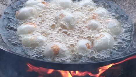 Extreme-close-up-Boiled-duck-eggs-on-Frying-hot-pan,-red-hot-fire