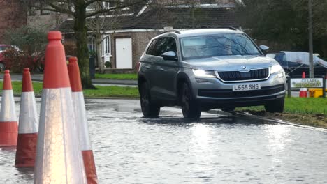 Storm-Christoph-car-riding-curb-rainy-flooding-village-road-splashing-street-cones
