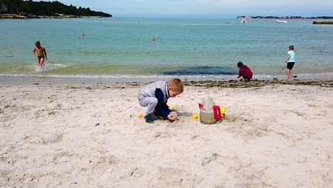 Kinder-Spielen-Mit-Sand-Am-Strand