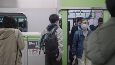 Pasajeros-Locales-Con-Máscaras-Faciales-Bajando-Del-Tren-En-La-Estación-De-Metro-Durante-La-Pandemia-De-Covid19-En-Tokio,-Japón