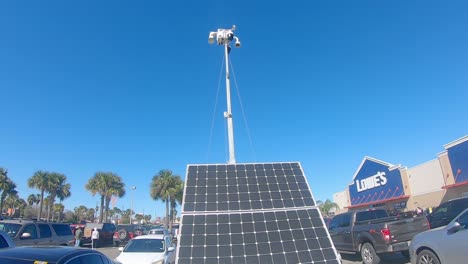 Pan-down-of-a-light-pole-that-is-solar-powered-and-mobile-light-used-for-security-surveillance-in-a-Lowe's-parking-lot