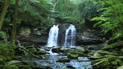 Una-Mujer-Joven-Se-Sienta-Al-Lado-De-Seneca-Falls,-Una-Gran-Cascada-Ubicada-A-Lo-Largo-De-Seneca-Creek,-Dentro-Del-área-Recreativa-Nacional-Spruce-Knob-seneca-Rocks-En-Virginia-Occidental