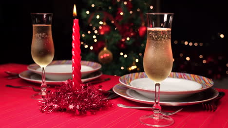 Pouring-champagne-on-a-Christmas-decorated-red-table-set