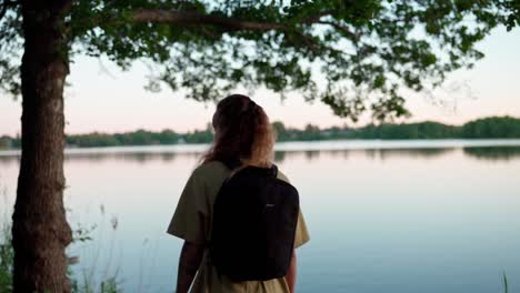 Backpacker-Traveler-Looking-On-Serene-Lake-At-The-Forest-Of-Norway