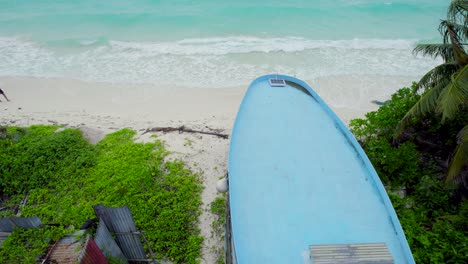 Aerial-view-of-an-abandoned-picturesque-blue-boat-in-the-seashore-of-Maldivian-island