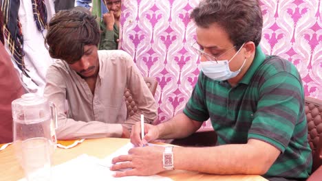 Helfer-Notieren-Einzelheiten-Von-Überschwemmungsflüchtlingen-Im-Hilfslager-In-Sindh