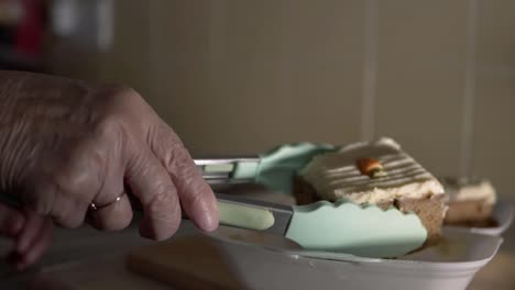 Hands-of-elderly-lady-serving-carrot-cake-close-up-shot