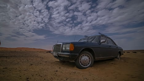 Mercedes-Benz-En-El-Desierto-Marroquí-Con-Un-Castillo-Histórico-En-El-Fondo-Y-Un-Lapso-De-Tiempo-Cloudscape-Sobrecarga