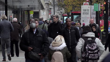 Menschen-Mit-Schützenden-Gesichtsmasken-Gehen-Während-Der-Coronavirus-Pandemie-An-Einem-Social-Distancing-Schild-In-Der-Oxford-Street-Vorbei