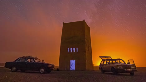 Time-lapse-shot-of-tourist-with-historic-mercedes-vehicles-watching-golden-sunset-and-flying-stars-at-night-sky-in-moroccan-desert