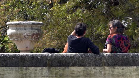 Un-Par-De-Turistas-Abrazándose-En-La-Plaza-De-Lisboa,-De-Pie-Y-Señalando-Con-La-Mano-Los-Puntos-De-Referencia