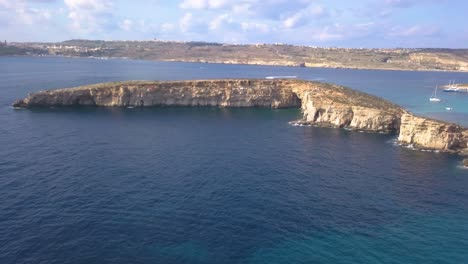 Wide-aerial-view-of-a-tiny-island-off-the-shore-of-Comino