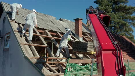 Construction-Workers-Dismantling-Corrugated-Roof-Tiles-Of-A-House-Under-Renovation