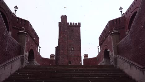 Snow-falling-in-front-of-the-famous-landmark-"Karnan"-castle-in-central-Helsingborg,-Sweden-a-cloudy-winter-day