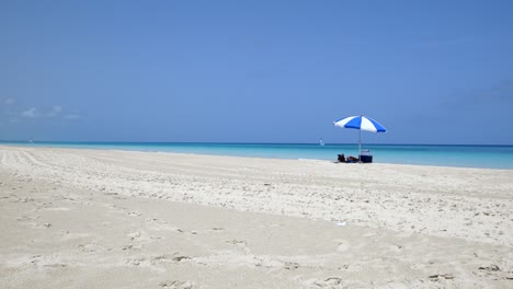 Fantastischer-Strand-Von-Varadero-An-Einem-Sonnigen-Tag,-Feiner-Weißer-Sand-Und-Türkisfarbenes-Und-Grünes-Karibisches-Meer,-Rechts-Ein-Blauer-Sonnenschirm,-Kuba