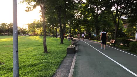 A-group-of-local-adults-walking-around-the-park-during-the-hot-afternoon