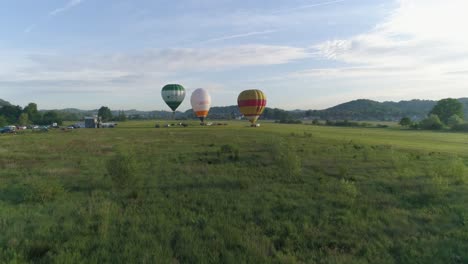 Forward-push-towards-balloons-as-sun-rises,-one-balloon-rising-above-the-rest