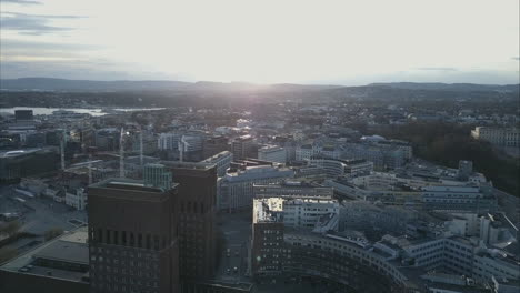 Aerial-shot-of-Oslo-City-Hal,-Rådhuset-and-construction-cranes-in-background,-Norway