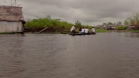 Small-boats-transporting-through-a-village-in-Iquitos,-Peru-on-the-Amazon-River