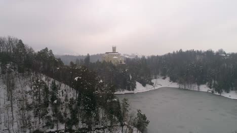 Aerial-view-of-frozen-lake-and-fairy-tale-castle-in-the-distance-at-winter