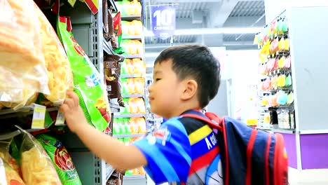 Niño-Asiático-Recogiendo-Bocadillos-En-El-Hipermercado