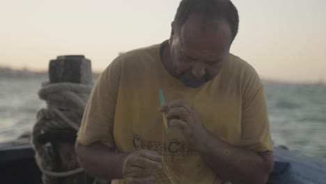 Greek-fisherman-repairs-net-traditionally-by-hand-SLOW-MOTION