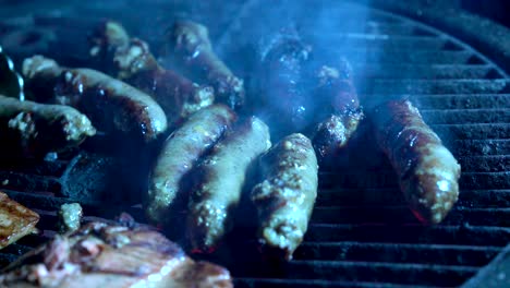 Sausages-on-a-hot-grill-with-tongs-picking-them-up-and-moving-them-around