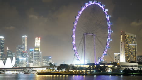 Singapore---Circa-Timelapse:-Marina-Bay-Sands-are-seen-throw-the-Singapore-Ferris-Wheel-at-night