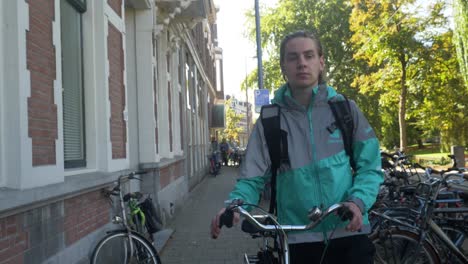 Clip-De-Un-Jinete-De-Deliveroo-Caminando-En-Una-Calle-De-Rotterdam-Mientras-Sonríe